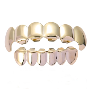 Gepolijste gouden hiphop tanden grillz set met hoektand ontwerp op witte achtergrond