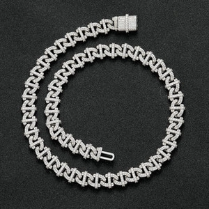 Macro shot of a silver curb chain necklace with pavé-set white zircons and square clasp