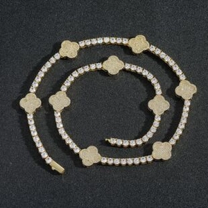Detailed macro view of gold clover pendants on a sparkling zircon link necklace