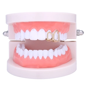 Macro detail van vergulde holle hoektand grillz sieraden op een tandmodel