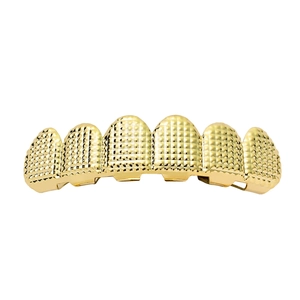 Detail of hip hop gold plated grillz with pyramid diamond cut texture on six tooth caps