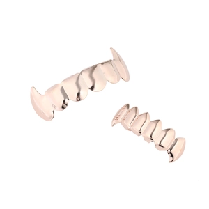 Macro detail of rose gold vampire fangs grillz set with high polished metallic finish