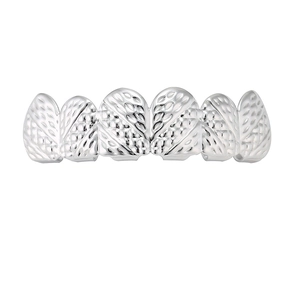 Macrodetail van zilveren hiphop grillz met ingewikkelde arcering en gegraveerde patronen