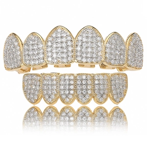 Hip hop gold plated grillz set with white zircon stones on a white background