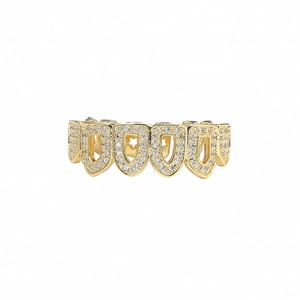 Gros plan de grillz hip-hop dorés avec zircons micro-pavés et design de bouclier creux