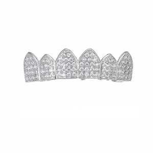 Close-up of silver-plated hip-hop grillz with pavé-set zircon crystals on six pointed teeth