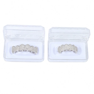 Detail view of silver hip-hop grillz set with pavé cubic zirconia in a display case