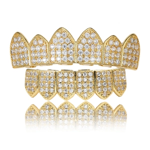 Ensemble de grillz hip hop dorés sertis de zircons sur fond blanc avec reflets