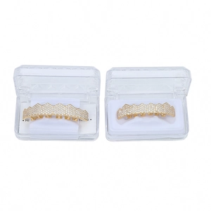 Detail view of gold-plated hip hop grillz with cubic zirconia stones in a display case
