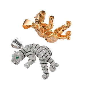 Macro view of 3D tiger pendant showing intricate pave zircon setting and green gemstone eyes