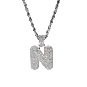 Detalle de colgante hip-hop letra N plateado con circonitas pavé en cadena de cuerda