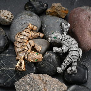 Macro detail of 3D tiger pendants with pave-set zircons and green gemstone eyes