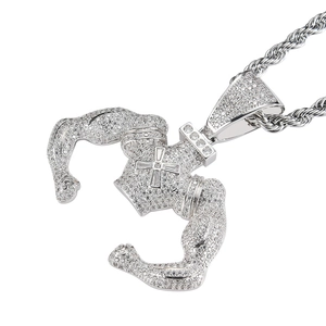 Macro detail of silver muscular body pendant with paved zircons and cross motif