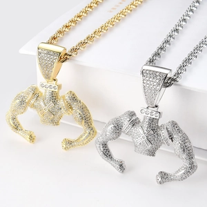 Macro shot of hip hop muscle man pendants in gold and silver with white zircon pavé