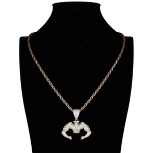 Macro shot of gold muscular man pendant with micro-pave zircons on a black neck bust