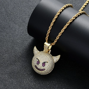 Gros plan du pendentif diable hip-hop avec zircons sur une chaîne en or de type corde