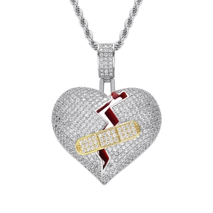 Détail du pendentif cœur brisé hip-hop avec zircons micro-incrustés et design de pansement doré