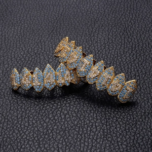 Makroaufnahme der goldenen Hip-Hop Vampir-Zahnschienen mit blauen und weißen Zirkonia