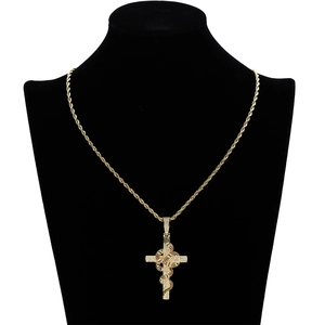 Détail du pendentif croix serpent en or avec zircons micro-pavés sur une chaîne torsadée