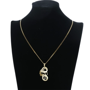 Macro detail of gold hip hop necklace featuring iced-out handcuff pendant with CUF letters