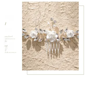Detail of bridal hair comb with handmade white flowers, rhinestones and pearls decoration