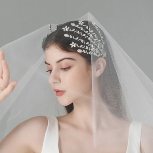 Detailaufnahme des Braut-Haarreifs mit Kristallen und weißem Schleier am Modell