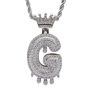Macro shot of silver hip-hop G-letter pendant with crown and dripping zircon details