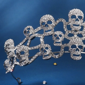 Macro detail of gothic silver crown featuring skulls and shimmering rhinestones
