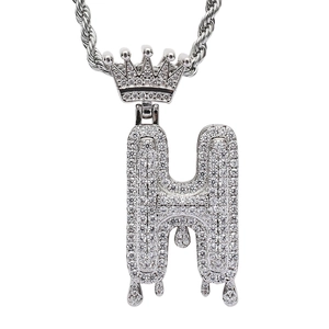 Macro detail of silver H letter pendant with full pave zircon stones and crown