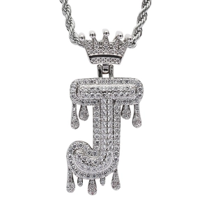 Macro detail of silver hip-hop letter J pendant with crown and dripping zircon design