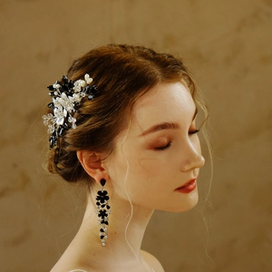 Detail of bridal hair comb with black flowers, white pearls, and matching drop earrings