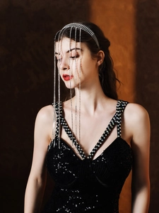 Détail du serre-tête argenté avec glands en strass et robe de soirée à paillettes noires