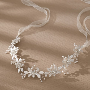 Détail du bandeau de mariée argenté avec perles et strass sur un fond de bois élégant