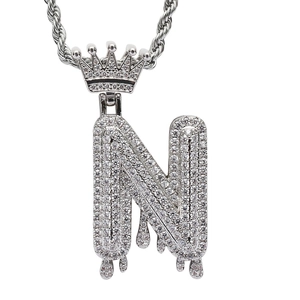 Macro detail of silver hip hop letter N pendant with crown and pavé zircons