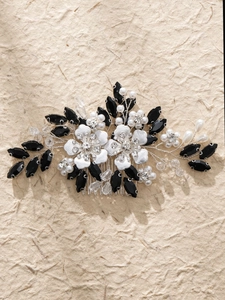 Close-up of handmade bridal hair comb with white flowers, pearls, and black rhinestones