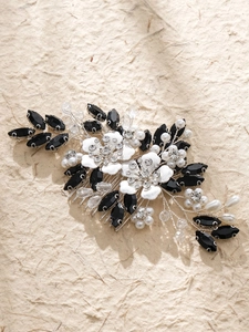 Detail of bridal hair comb with resin flowers, black crystals, and pearls on silver wire