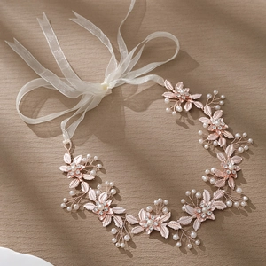 Détails d'un bandeau de mariée en or rose avec perles et rubans en organza pur