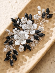 Detailed close-up of handmade bridal hair comb with silver flowers and pearls
