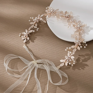 Détail du bandeau de mariée avec feuilles dorées, perles blanches et accents en cristal