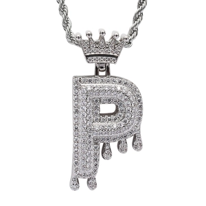 Macro shot of silver letter P pendant with crown detail and drip design in iced-out stones
