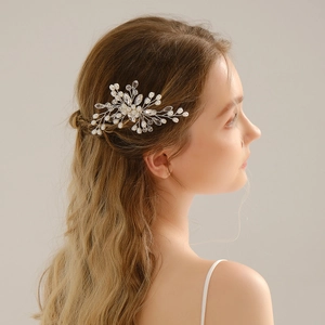 Dettaglio del pettine per capelli da sposa con perle e cristalli su acconciatura elegante
