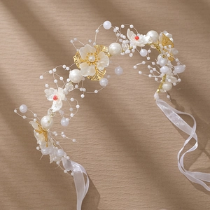Détail du bandeau de mariée fait main avec des perles blanches et des feuilles dorées
