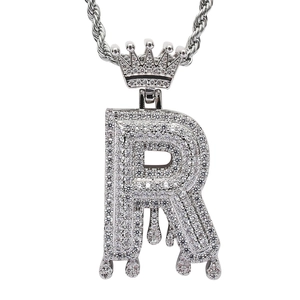 Macro view of iced out letter R pendant with crown detail and micro-pave zircons