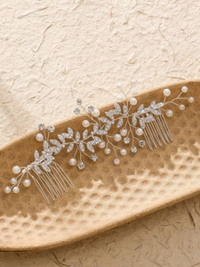 Détail du peigne de mariée avec perles blanches et feuilles de vigne en strass brillants