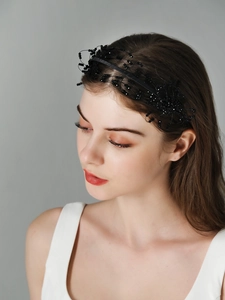 Detail of handcrafted black beaded floral headband on a model with elegant mesh texture