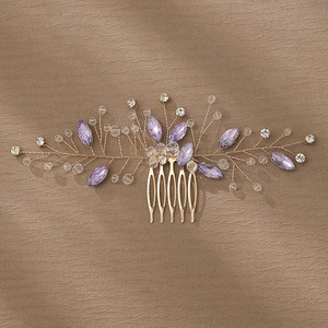 Close-up of handmade bridal hair comb with purple crystals and gold wire details