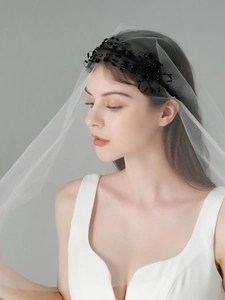Detail of handmade black beaded headband with white bridal veil on a side-view model