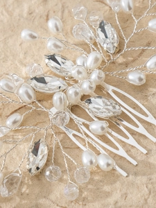 Dettaglio macro del pettine da sposa con filo d'argento, perle bianche e strass chiari