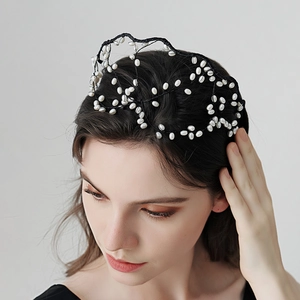 Détail d'un serre-tête de mariée tissé à la main avec perles blanches et structure en maille