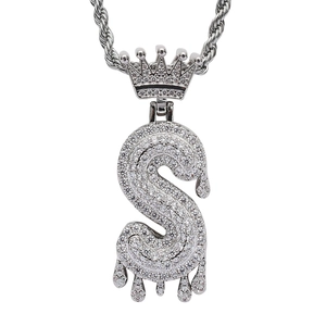 Macro shot of silver hip hop S letter pendant with crown and dripping water details